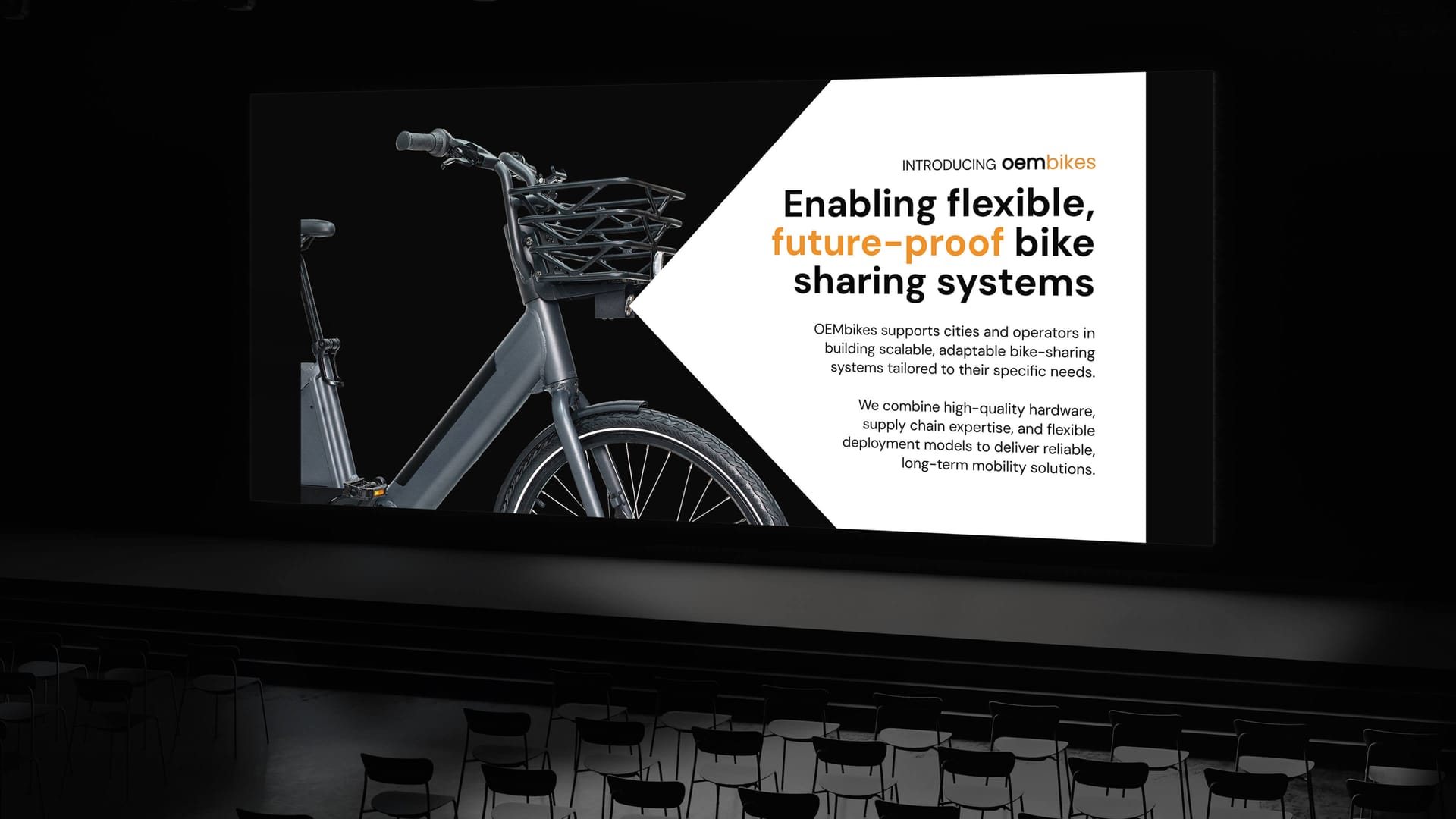 OEMbikes presentation screen mockup in theatre showing Enabling Flexible Future Proof Bike Sharing Systems slide, presentation design by On Poynt Creative