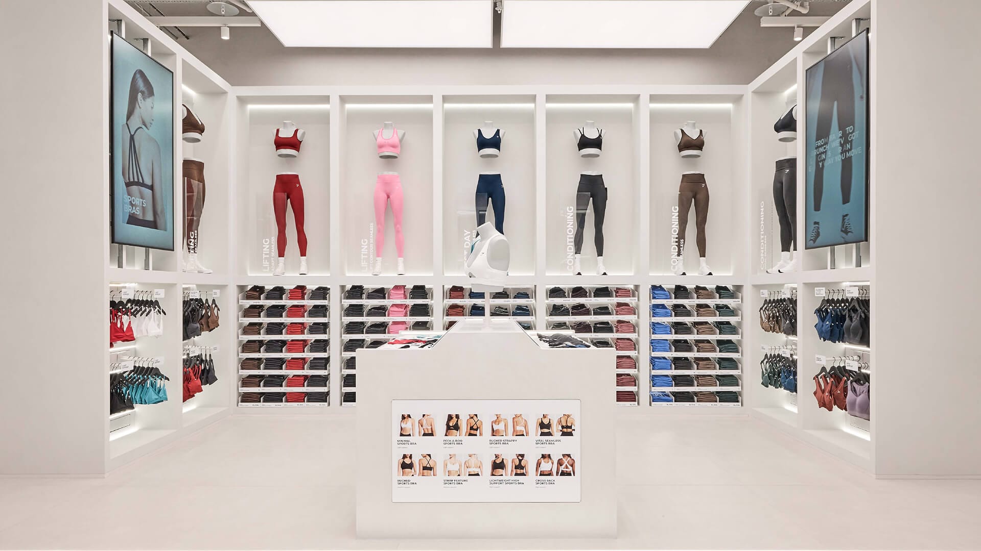 Gymshark Stratford store activewear display wall with mannequin outfits and product information table, retail design by On Poynt Creative